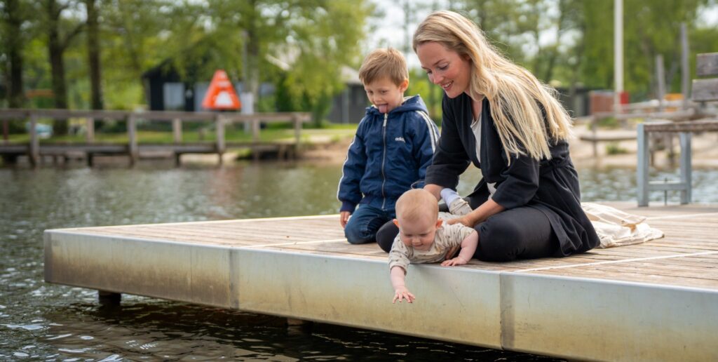 Billede af Nanna med to børn på en badebro ved Tange Sø