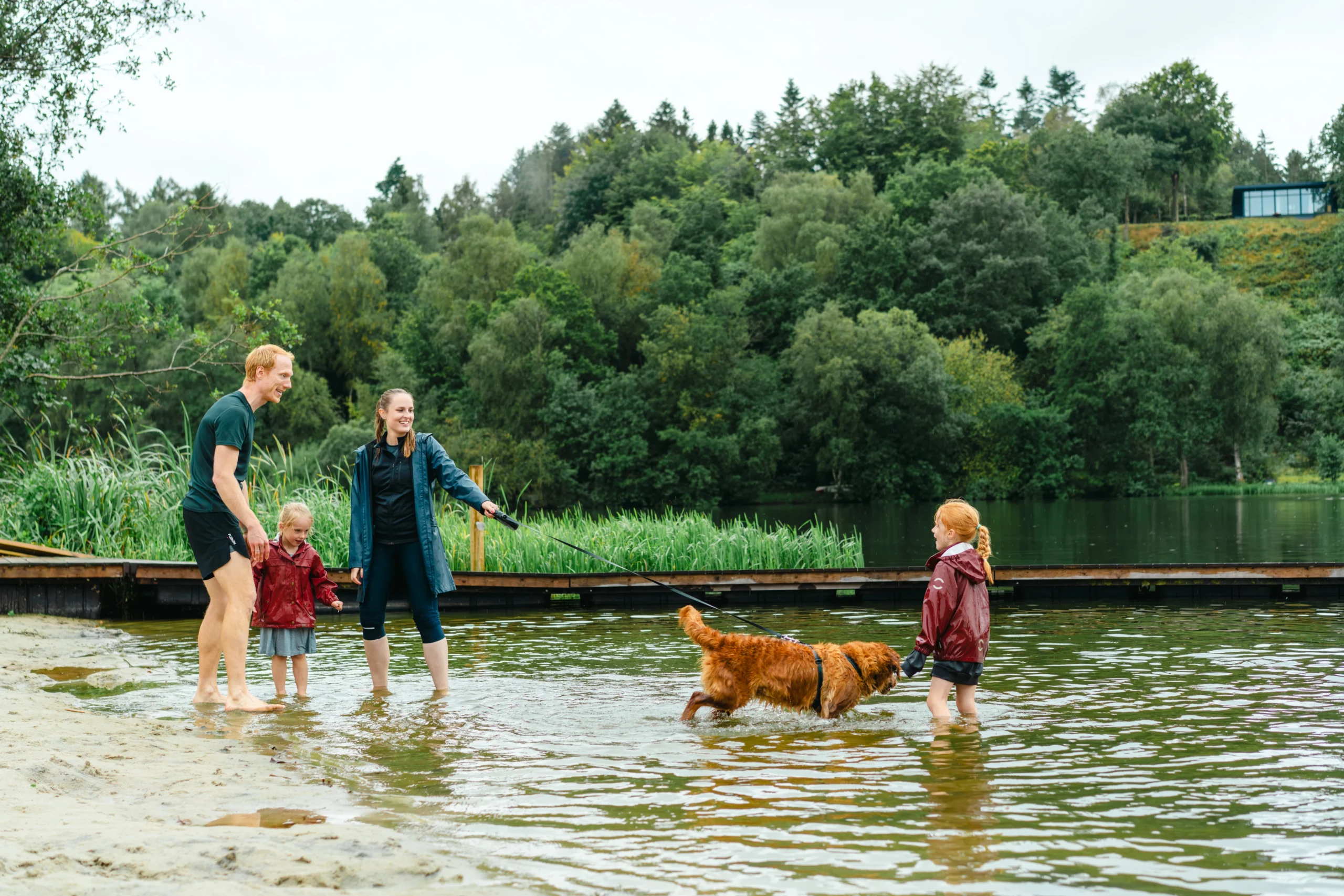 mor, far, to døtre og hund sopper rundt ved Bryrup Langsø