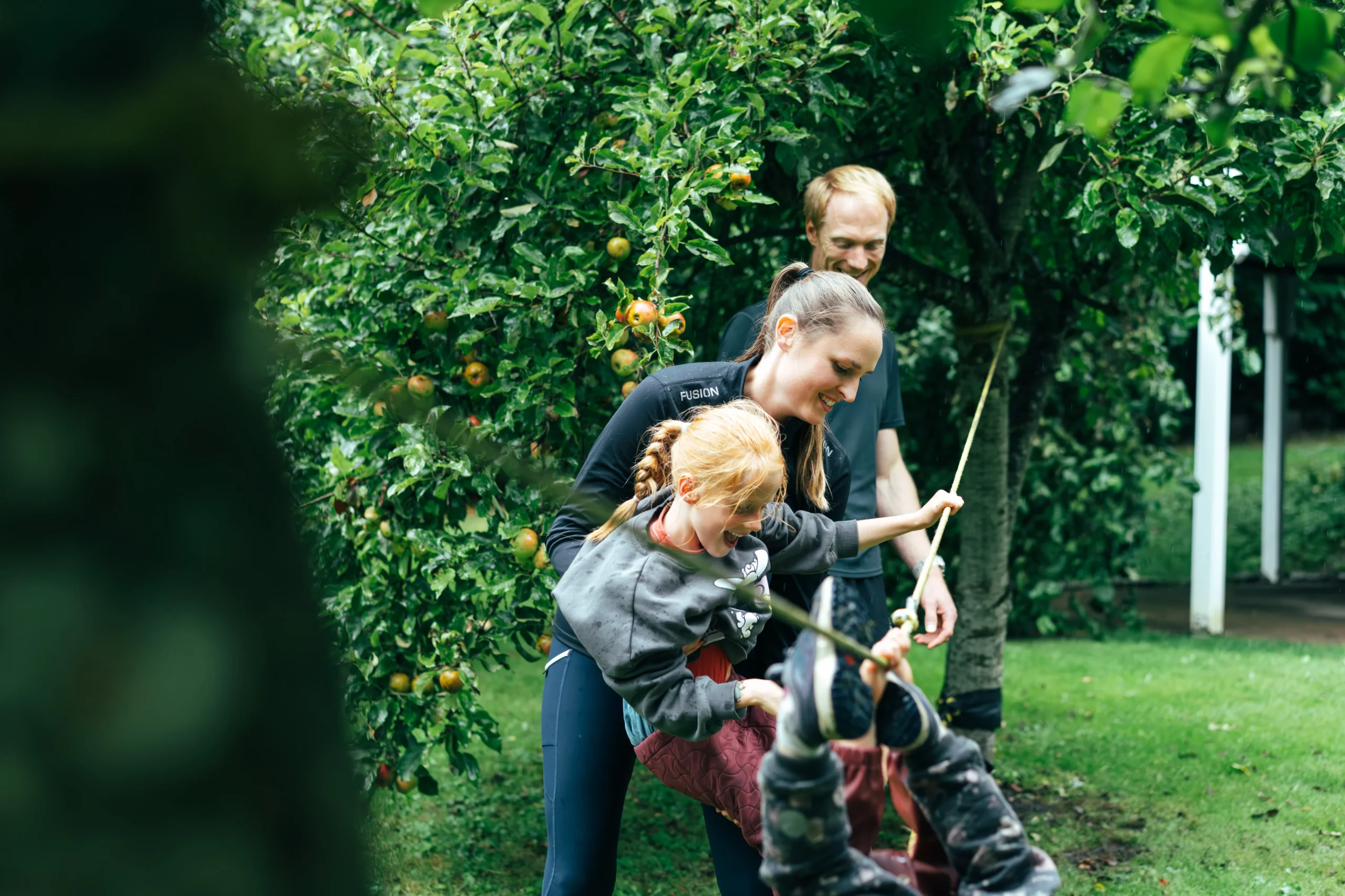 de to børn kravler på slackline imens forældrene kigger med