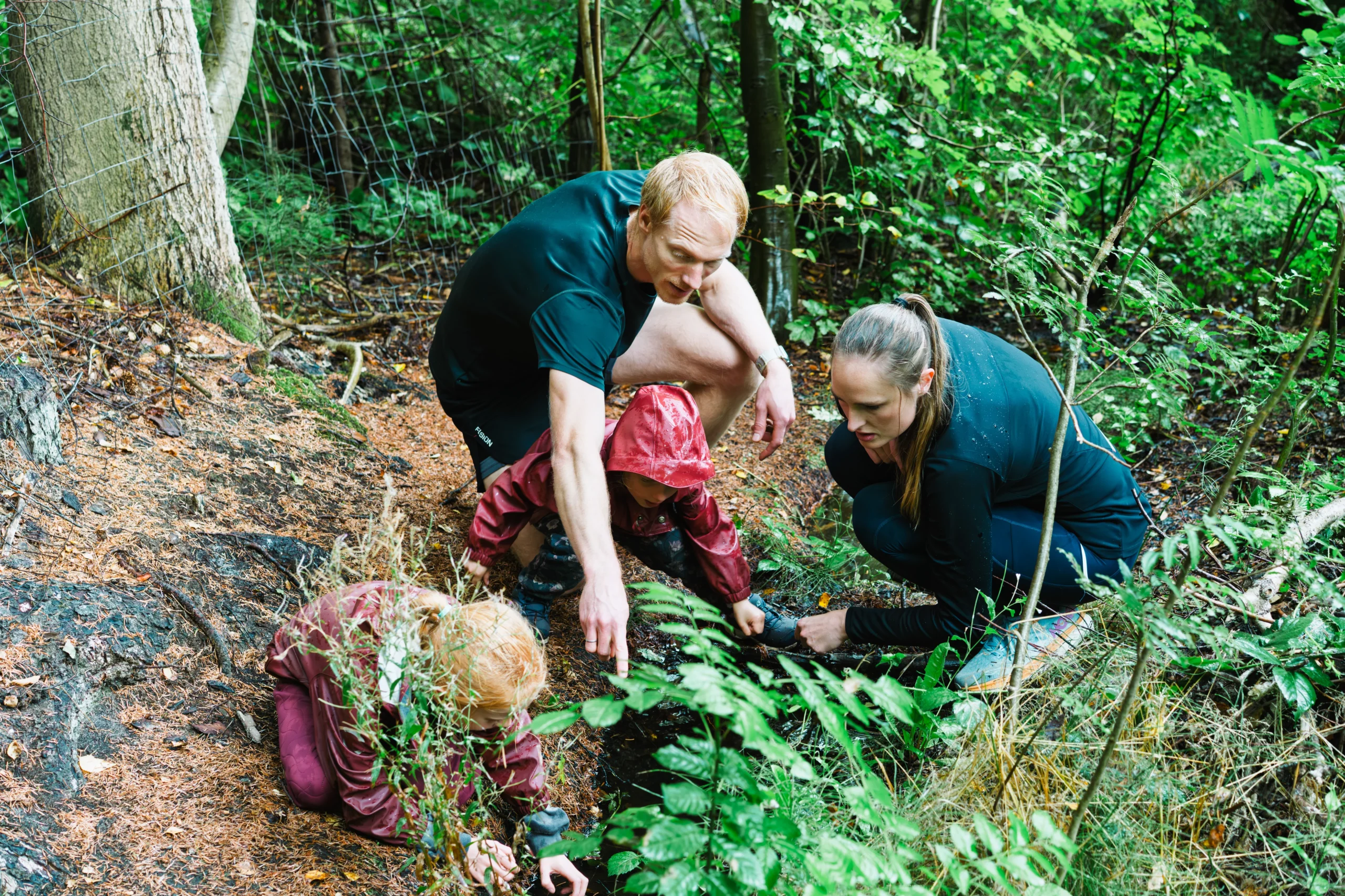 hele familien betragter de små dyr i åen, fra skovstykket på deres grund